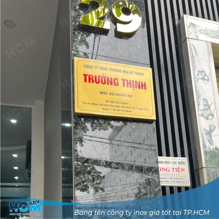 Bảng hiệu tên công ty inox vàng lắp trên nền đá đen sang trọng