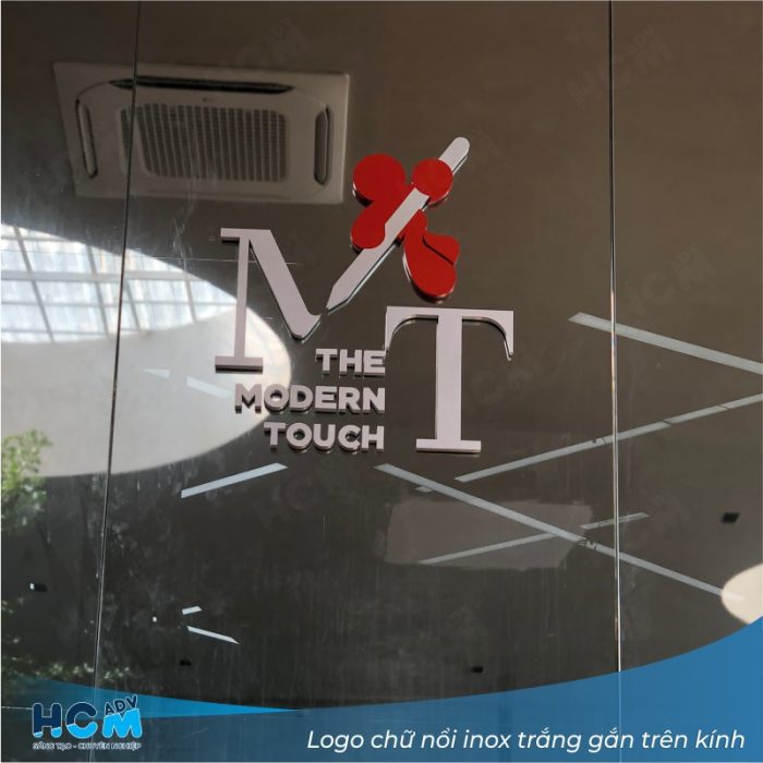 Logo chữ nổi inox trắng gắn trên kính tại công ty kiến trúc