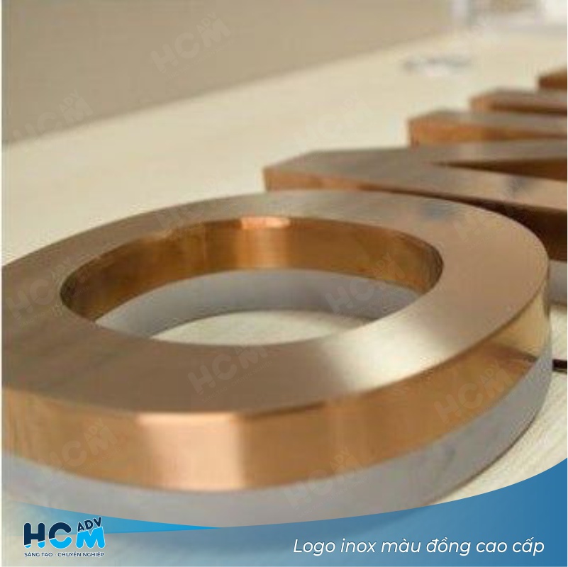 Logo inox màu đồng nổi bật tại quầy lễ tân công ty nội thất cao cấp Logo inox màu đồng nổi bật tại quầy lễ tân công ty nội thất cao cấp